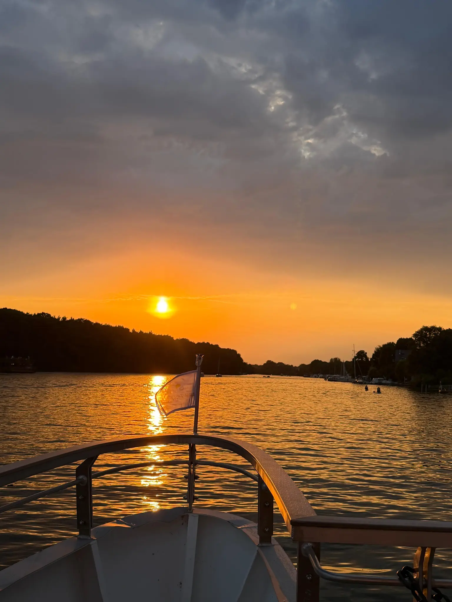 Sonnenuntergang über dem Wasser vom Bug des Ausflugsboots