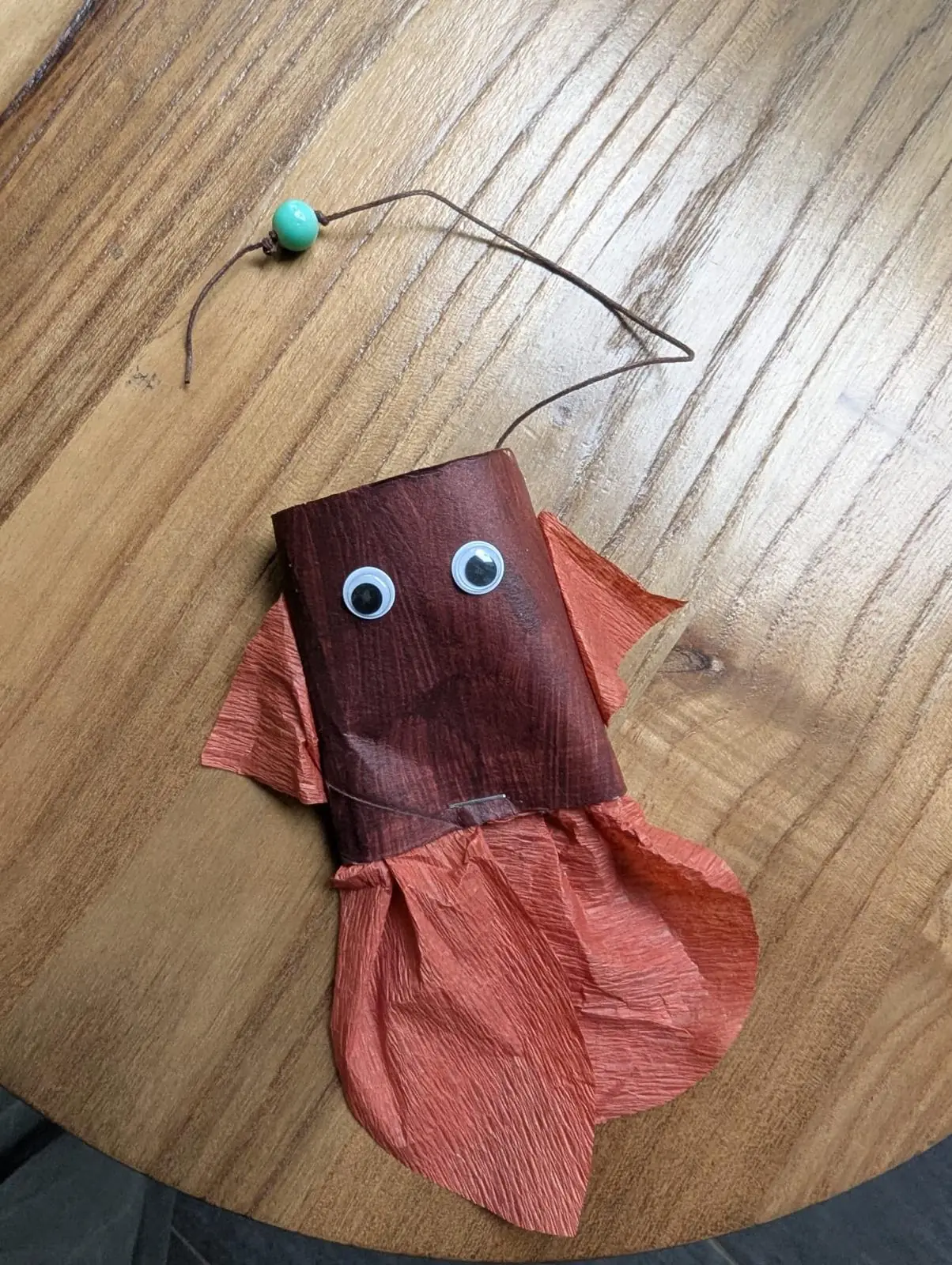 Gebastelte Krake aus einer Papprolle mit Wackelaugen und Armen aus Krepppapier